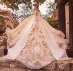 Vestido de novia con capa y bordados dorados, ideal para boda o XV años en entorno rústico