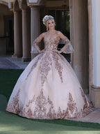 Mujer con vestido de XV años rosa claro con aplicaciones doradas, posando en exterior elegante.