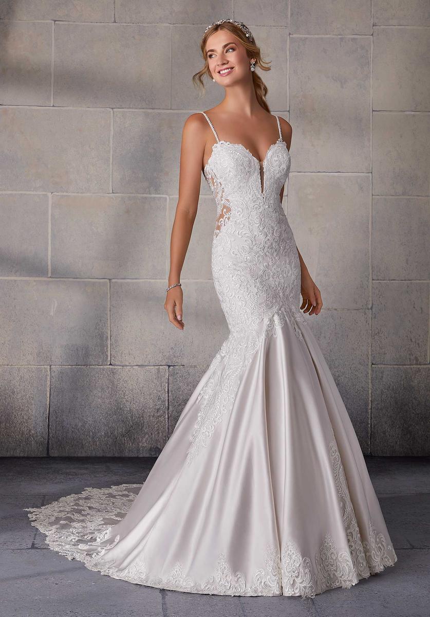 Mujer con vestido de novia blanco, corte sirena, encaje y cola larga, fondo neutro elegante.