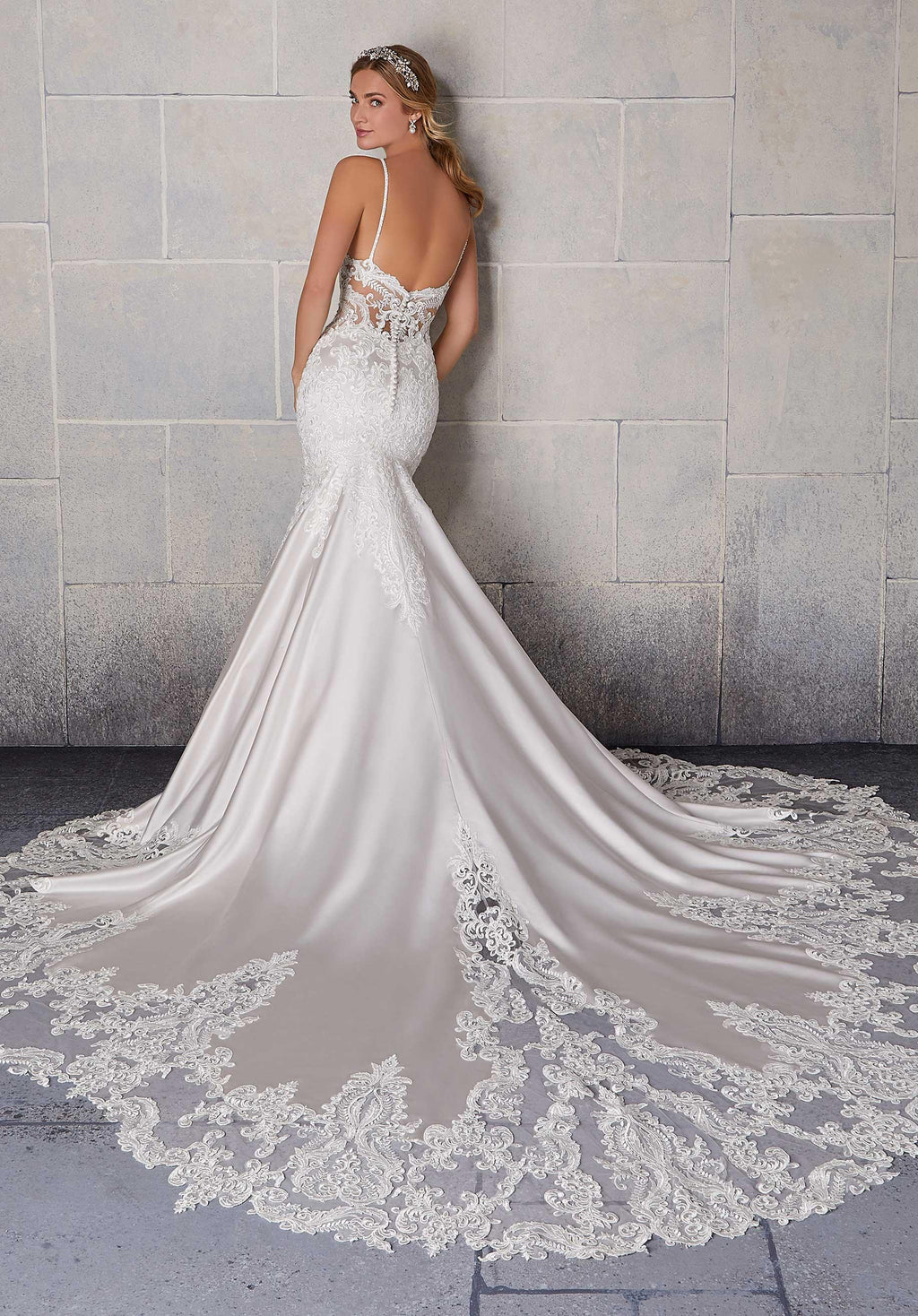 Vestido de novia blanco con encaje, escote en la espalda y cola larga elegante.
