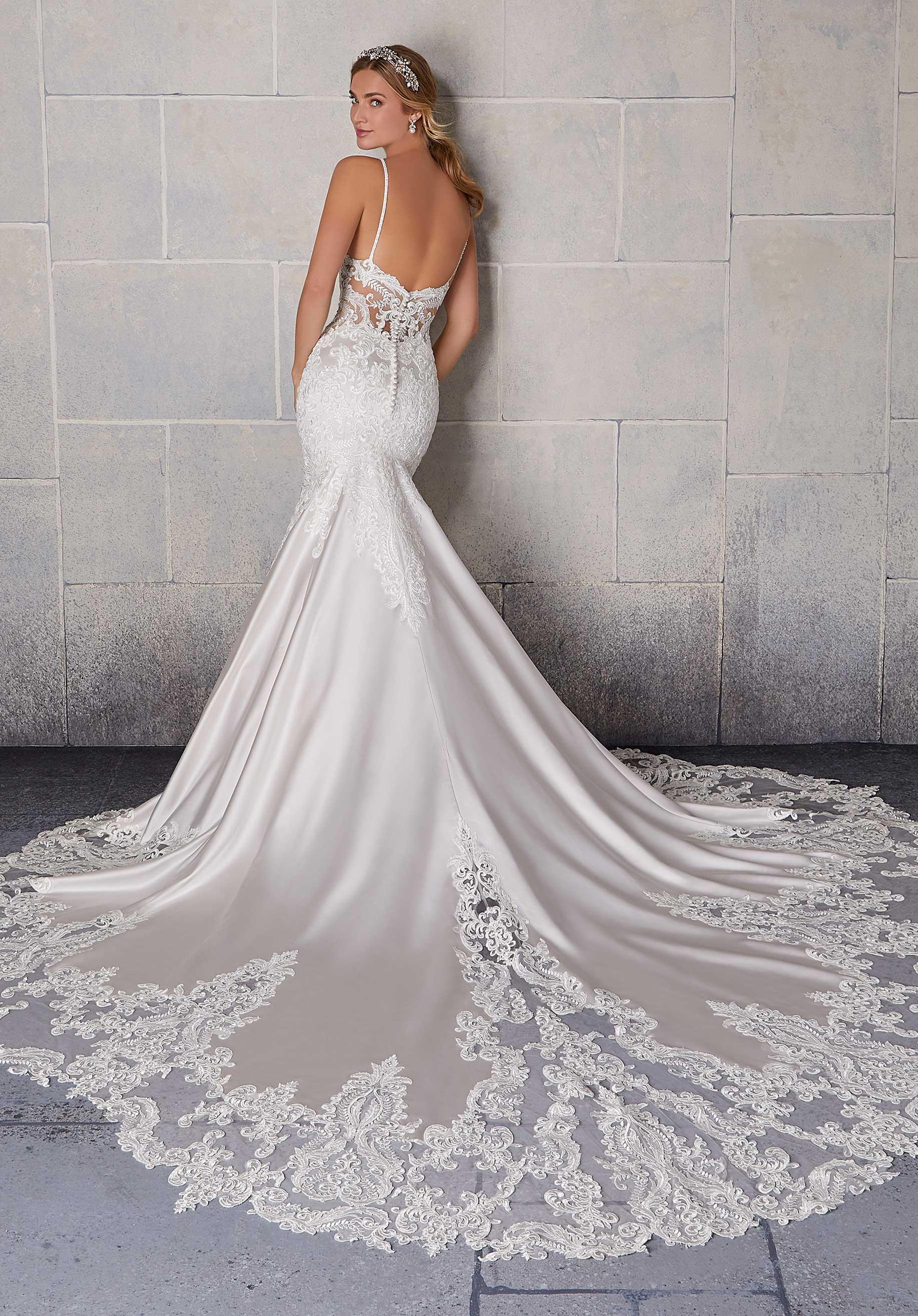 Vestido de novia blanco con encaje, escote en la espalda y cola larga elegante.