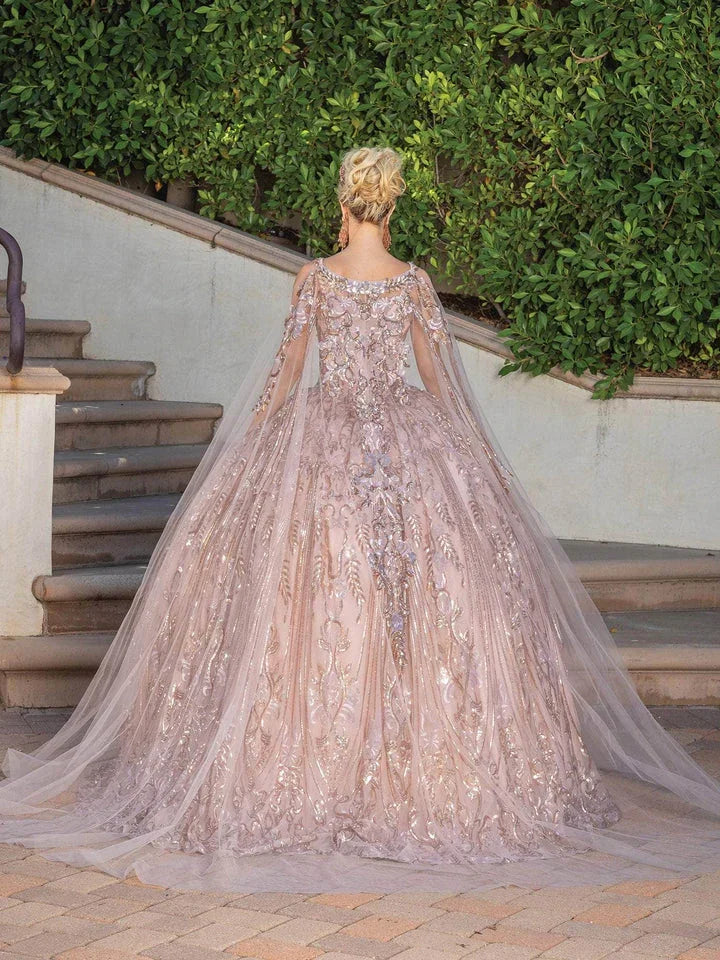 Vestido de quinceañera elegante rosa palo con tul y bordados, modelo de espaldas al aire libre.
