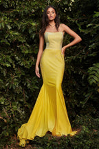 Mujer con vestido largo amarillo elegante de gala, detalles brillantes, fondo de naturaleza.