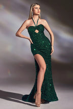 Mujer con vestido largo verde esmeralda de lentejuelas, escote halter y abertura en la pierna.