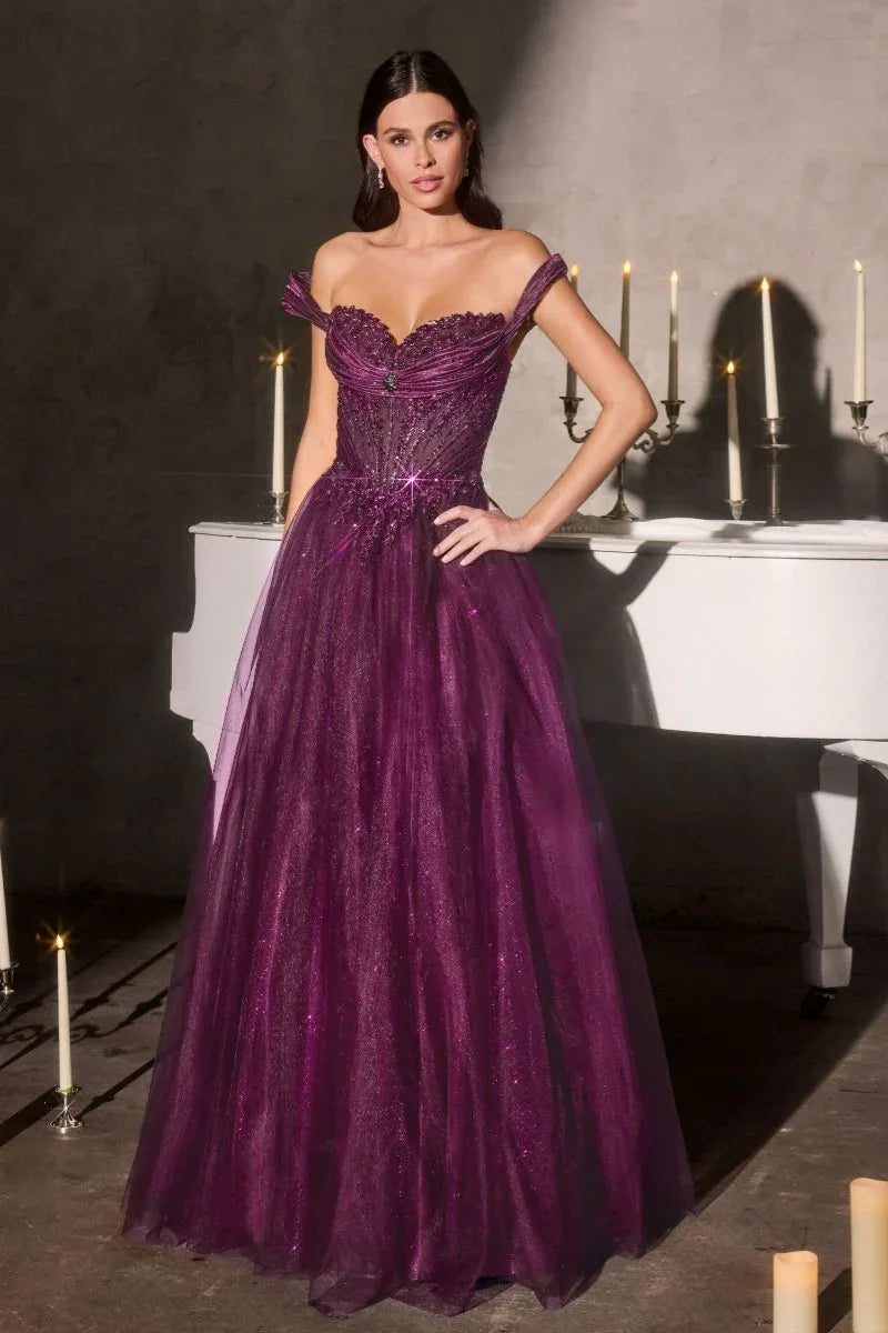 Mujer con vestido de gala morado brillante, escote corazón, junto a piano blanco y velas.