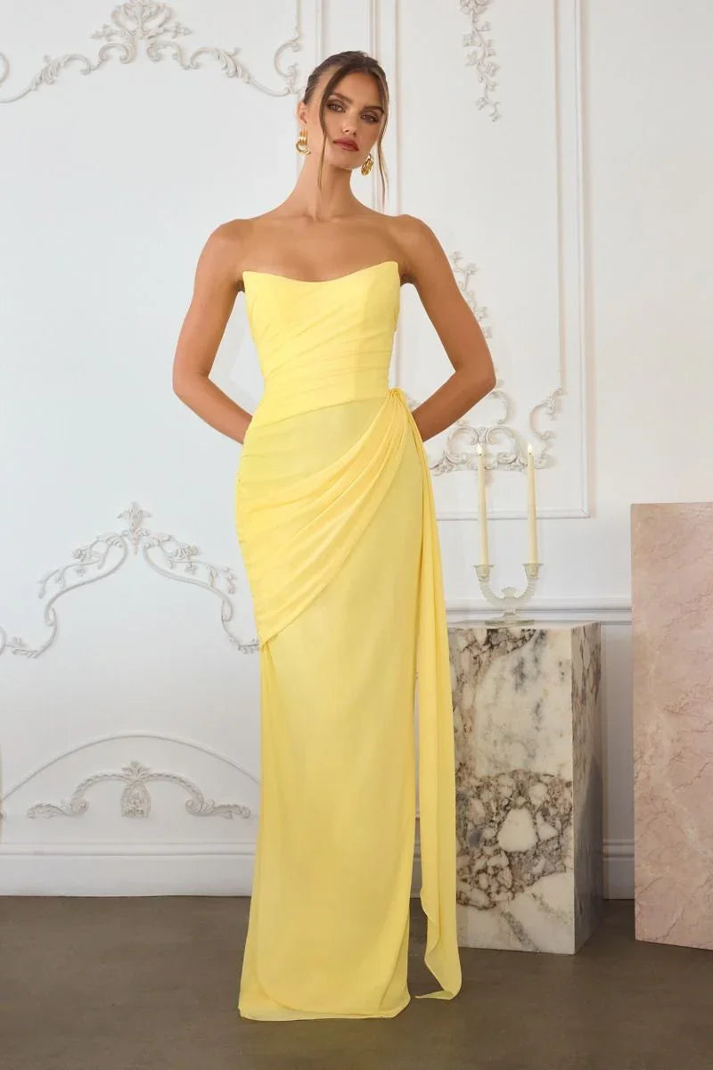 Mujer con vestido largo amarillo sin tirantes, ideal para fiesta o evento elegante.