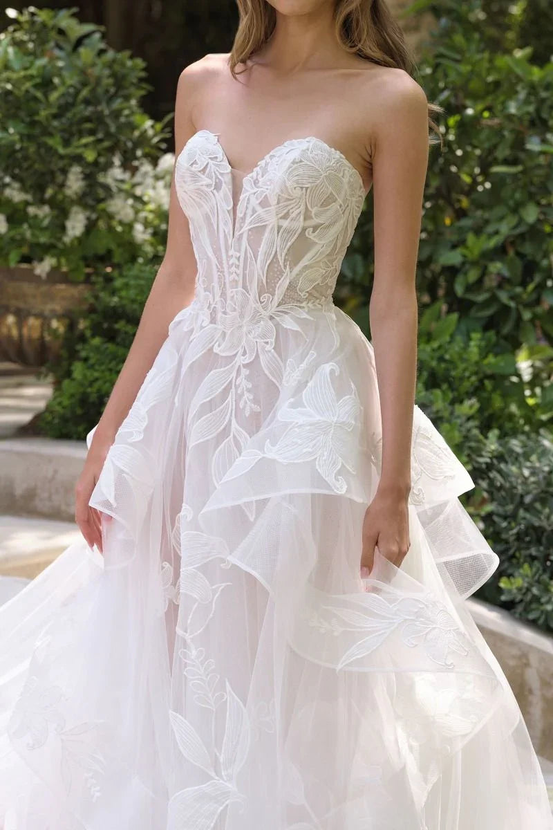 Vestido de novia strapless con tul y bordados florales, ideal para boda o fiesta elegante.