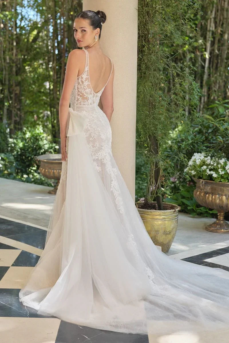 Vestido de novia elegante con cola larga de encaje y tul en jardín, diseño espalda descubierta.