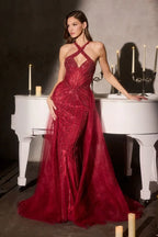 Mujer con vestido de gala rojo brillante con tirantes cruzados, junto a piano blanco y candelabros, ideal para XV años o fiesta elegante.