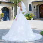 Vestido de novia blanco tipo princesa con encaje, mangas largas y velo, en exterior elegante
