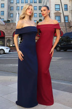 Dos mujeres con vestidos largos de gala, uno azul marino y otro burdeos, en la calle