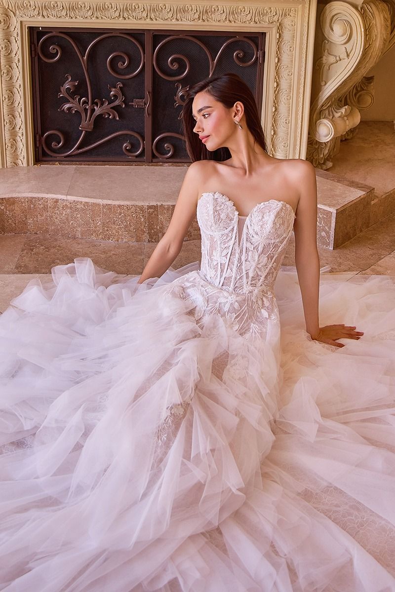 Novia con vestido blanco palabra de honor con corsé bordado y falda de tul voluminosa.