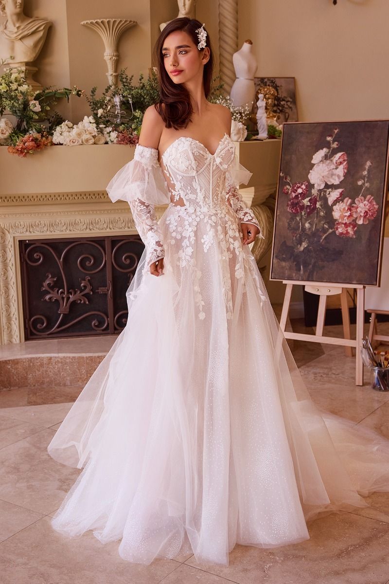 Vestido de novia blanco con encaje floral, escote corazón y mangas largas transparentes.