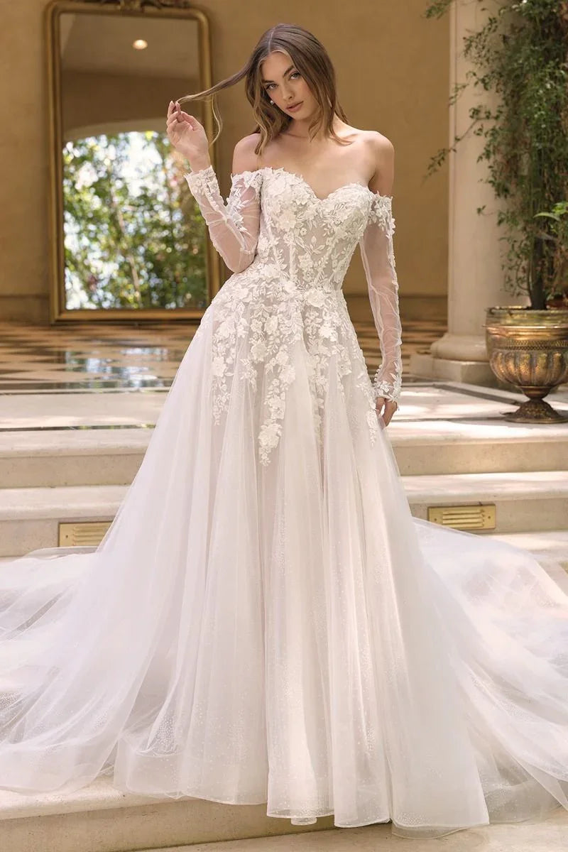 Vestido de novia blanco con encaje floral y mangas largas, corte princesa, en escaleras elegantes.